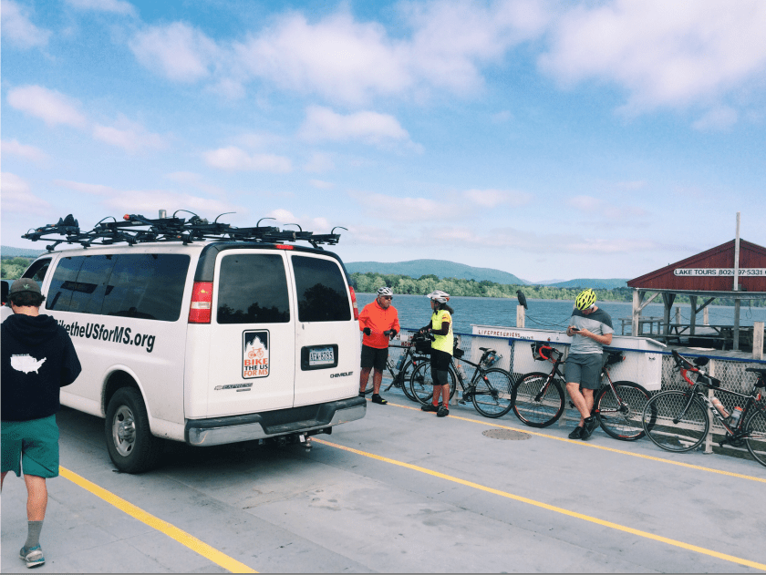 A van on a boat next to some bikes ferrying over to New York